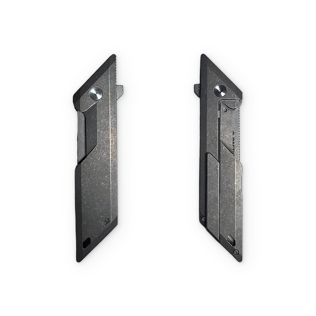Two slim black utility knife blades shown side by side on a plain white background, displaying both the serrated and unserrated sides.